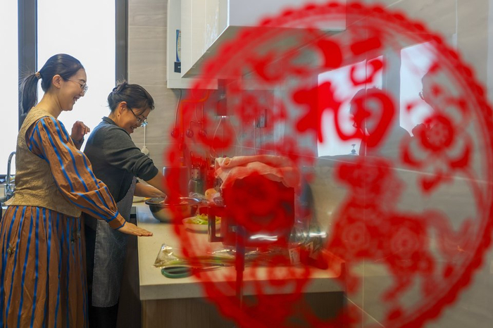 中午时间，牛佩瑶（左）和父母一起在雄安家中的厨房做午饭。人民日报记者 张武军摄
