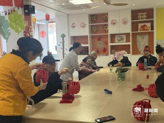杭州绿康丁兰家园，护理员、社工、志愿者与老人共同制作红灯。记者 王逸群 摄