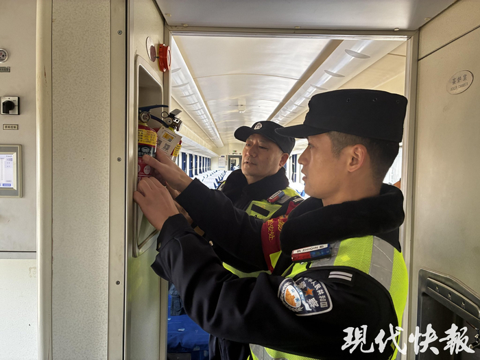 王强和同事在车厢内检查消防器材