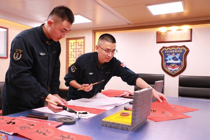 2月14日，海军衢州舰在海上执行战备巡航任务时，官兵利用休息时间写春联。