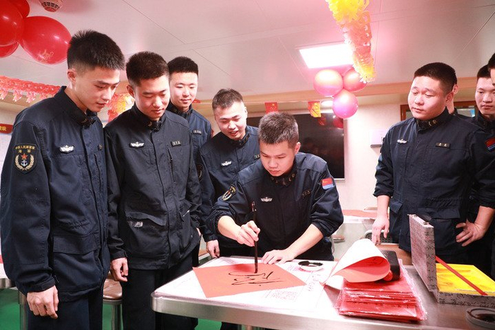 2月14日，海军衢州舰在海上执行战备巡航任务时，官兵利用休息时间写春联。