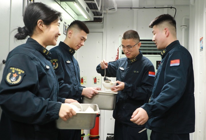 2月17日，海军衢州舰在海上执行战备巡航任务时，非当更官兵给正在战位上值班的战友送饺子。