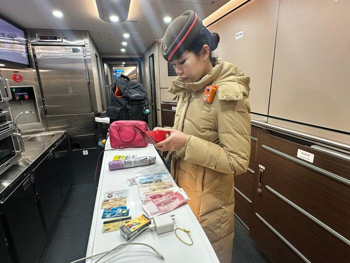 列车员方晴正在清理遗失物品。曹雨桐 摄