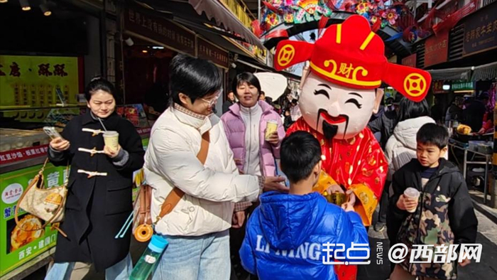 财神扮相的工作人员给游客送祝福