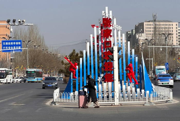 2月20日，一名前往京张高铁张家口站的旅客路过带有冬奥会标志的欢迎牌。新华社记者 唐霁 摄