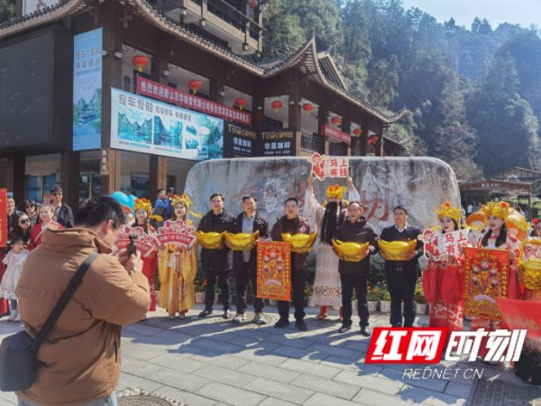 张家界宝峰湖景区工作人员与游客合影。