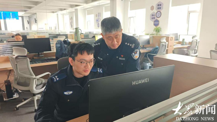 刘兆戈（右一）在与值班同事分析警情 郭由 摄