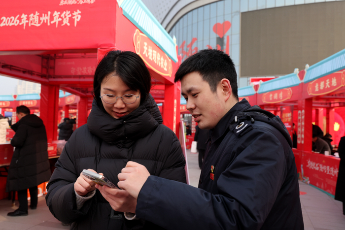 国家税务总局随州市曾都区税务局税务干部为商户讲解如何在手机上开具数电发票。