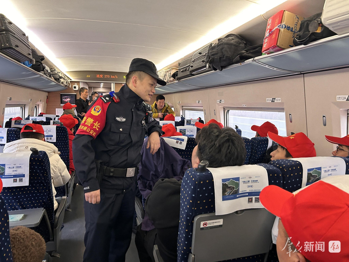 列车乘警向外出务工人员介绍相关安全防范知识。