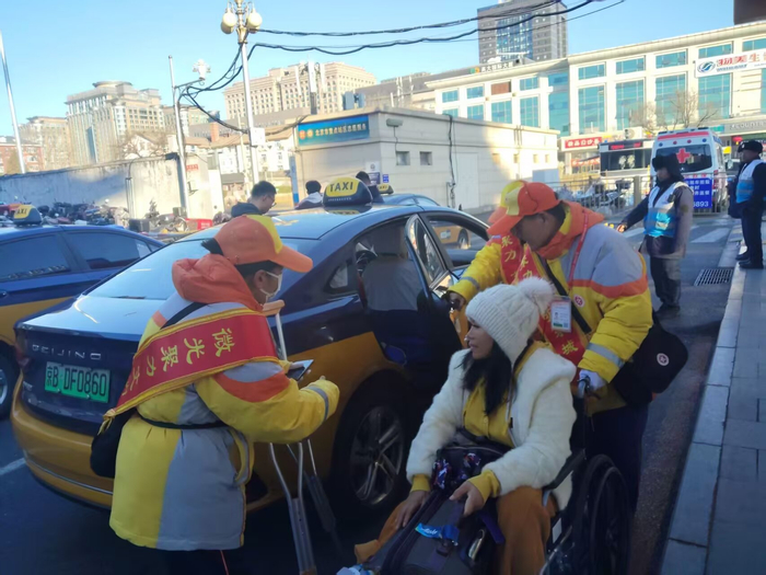 春运期间，公共文明引导员在北京站帮助旅客。