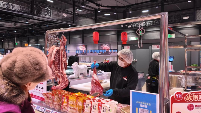 永辉超市肉禽技工崔师傅在为顾客分切肉 图/宋琦钰 摄