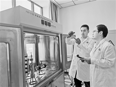 在中国石油化工股份有限公司西北油田分公司实验检测技术中心，黄诗文（右）正在进行实验记录。    本报记者 梁乐摄