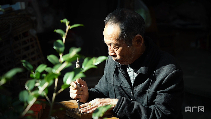 许汝良正在雕刻甲马版画（央广网记者  魏文青  摄）