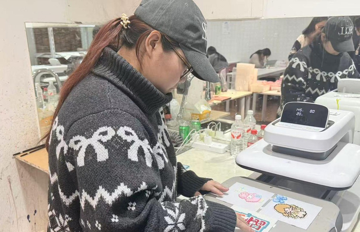 蒙蒙正在帮顾客烫豆。记者 戴佳轶 摄