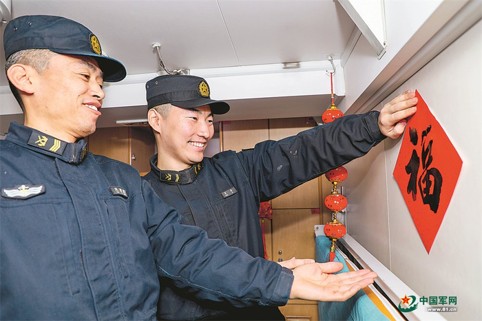 　　二级上士张琳（右一）与战友在舱室里贴福字。张 楠摄
