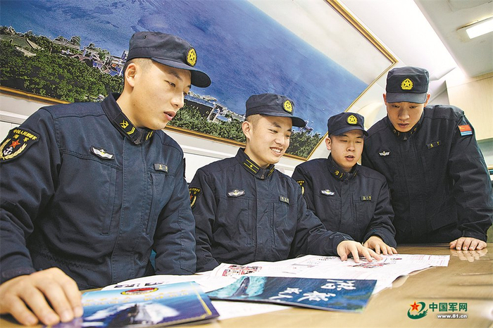 　　“砺刃报”主编倪呈辉（左二）与战友围看新一期“砺刃报”。 张  楠摄