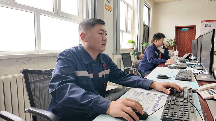 鲁超看着实时跳动的供回水温度、压力等数据，密切监测设备运行状态。