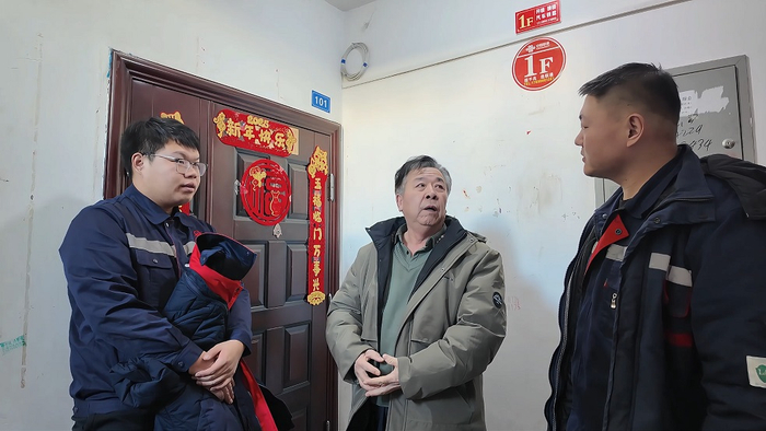 鲁超与同事走进居民家中，与群众交谈，了解供暖需求。