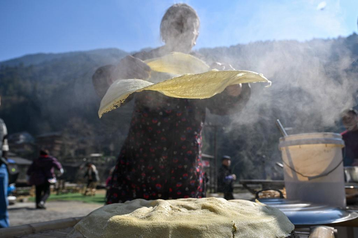 　　周友云在做烫豆皮。新华社发（陈绪开 摄）
