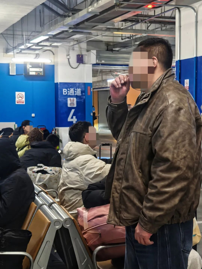 北京朝阳站网约车候车区内，有人在禁止吸烟的区域吸烟。