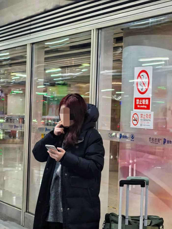 首都机场3号航站楼网约车西上客区，不少人无视提醒仍在吸烟。