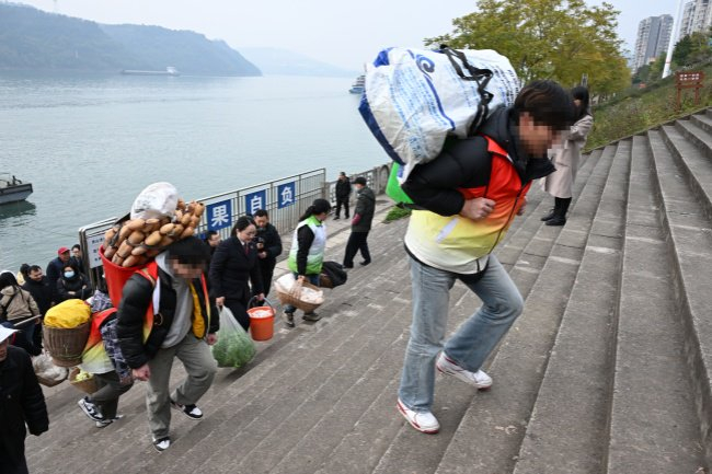 今年2月，重庆市忠县检察院检察官和社工组织帮教少年帮助菜农卖菜。　本报通讯员江泳摄