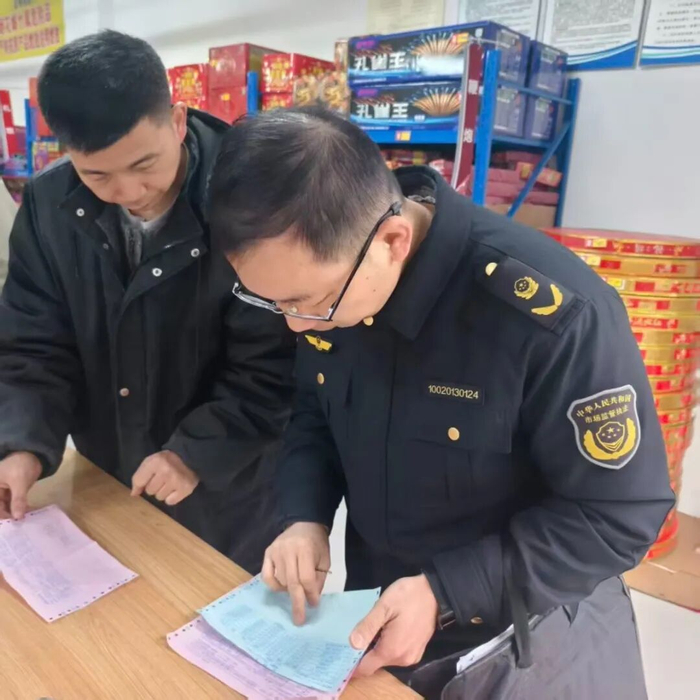 图为2月16日（除夕）锡山区市场监管局监管人员在检查锡山区商务区一烟花爆竹零售点。