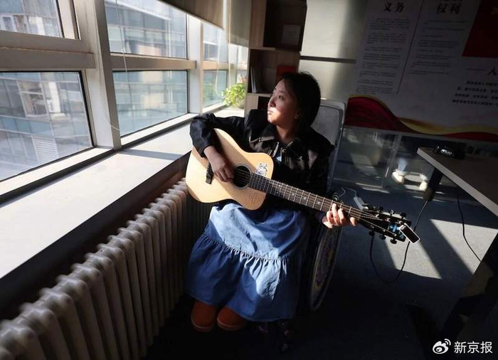 崔莹在弹奏吉他。