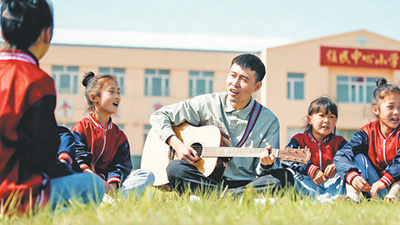 李平和“村里的孩儿”在学校前的草坪上歌唱（资料图片）。