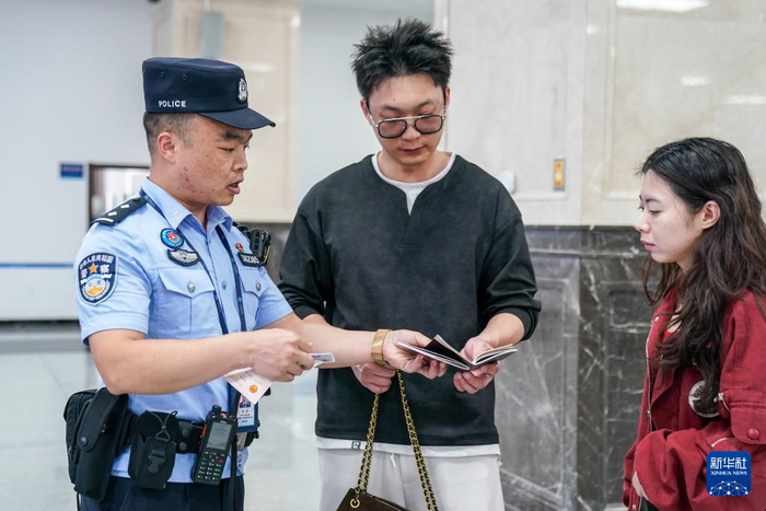 2月26日，河口边检站执勤民警为旅客办理边检手续。新华社记者 彭奕凯 摄