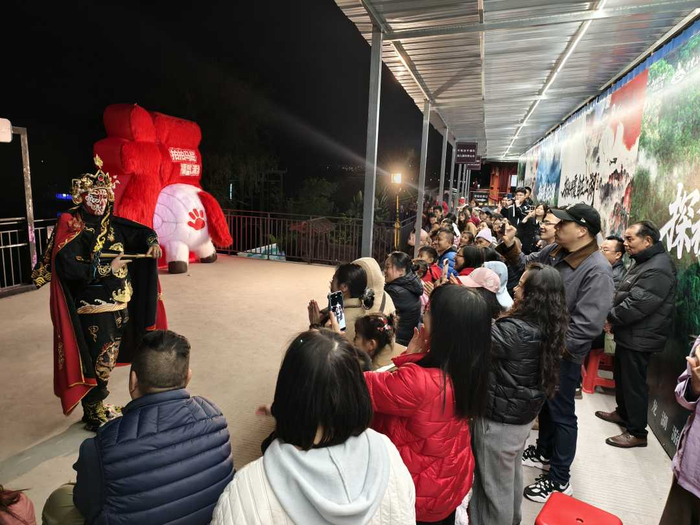 丹霞山游客等候游船间隙欣赏变脸艺术。（资料图片）