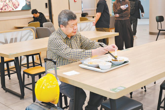 图为顾客正在品尝炒菜机器人烹制的菜品。 本报记者 夏骅摄