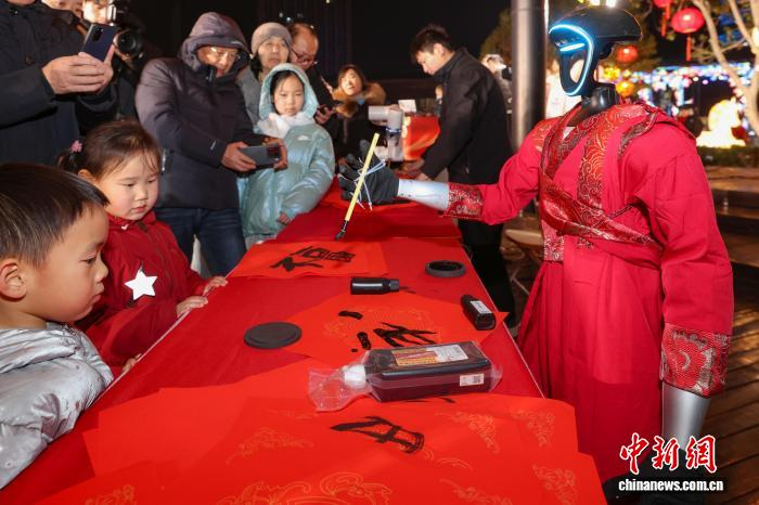 文能手写春联，武能跳舞后空翻，机器人成了老人孩子都喜欢的金牌“演员”。泱波 摄