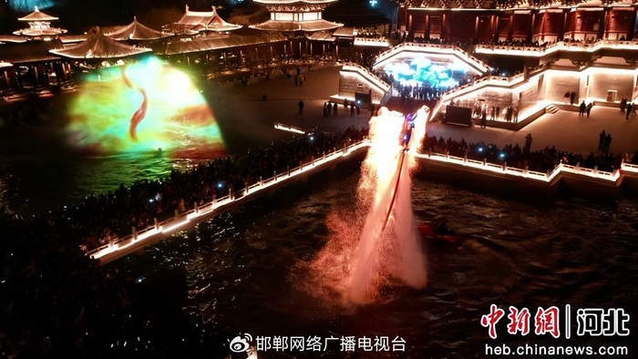 图为游客观看光影秀、火壶表演。 习守政 摄