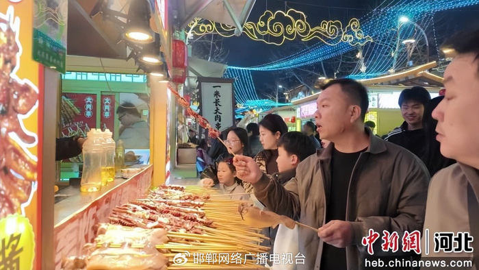 图为游客在大名集荟购买小吃。 习守政 摄