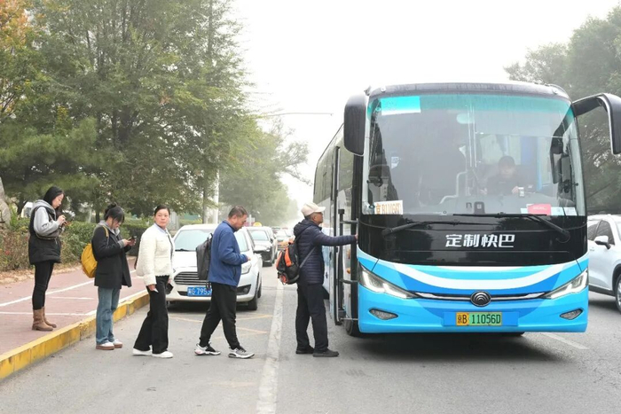 廊坊三河市燕郊镇燕京航城南门公交站点，市民正在排队乘坐驶向北京的定制快巴。王伟摄