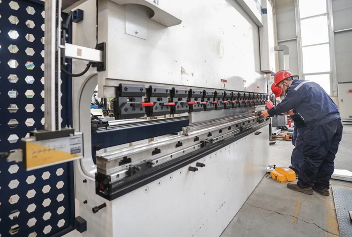 在市经开区的河北新珑智控生产车间内，工人们操作数控折弯机加工新能源装备部件，加班加点赶生产。霍红军、李院红摄