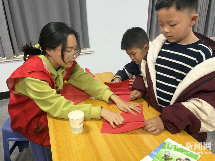 志愿者教孩子们手工折纸