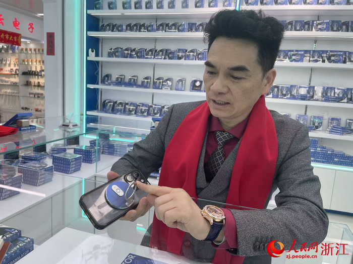 张筠介绍可以当手机支架的AI翻译机。人民网记者 王丽玮摄