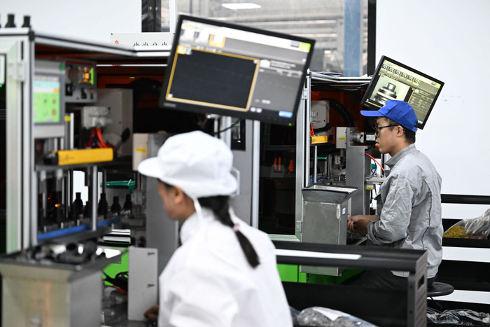 工作人员在天津鹏翎集团股份有限公司生产车间操作半自动生产设备生产汽车胶管接头。新华社记者 赵子硕 摄