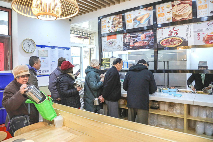 老人排队在老年食堂打饭。董芳忠摄