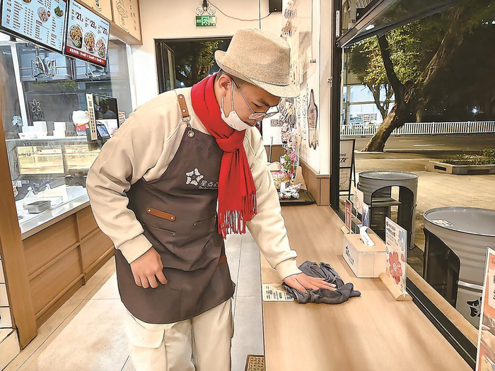 孤独症青年正在擦桌子。