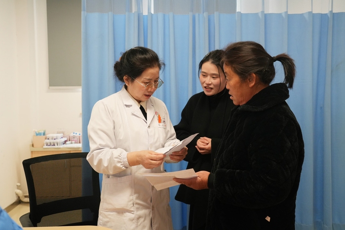 全国人大代表、江西省妇幼保健院肿瘤科副主任胡小青（左一）接诊病人（吴国东 摄）