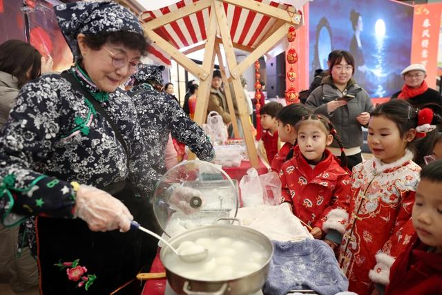 洪桂玉忙着给孩子们煮汤圆，赖鑫琳摄