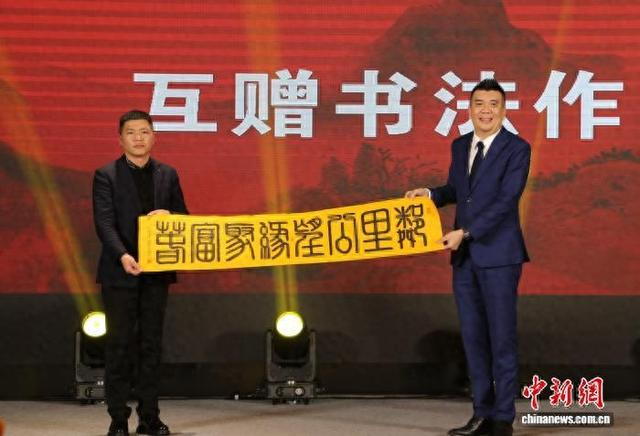 3月1日，两岸同胞互赠书法作品。图为台湾乡亲将“邻里公望·缘聚富春”书法作品赠予大陆同胞。郭其钰 摄