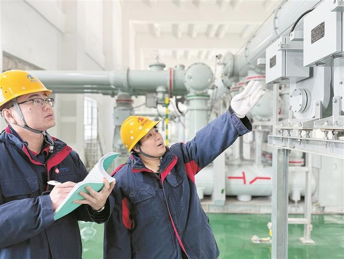     2月16日，刘斐斐（右）在检查站内设备运行情况。    兵团日报常驻记者  张婷婷  通讯员  吴一凡  摄