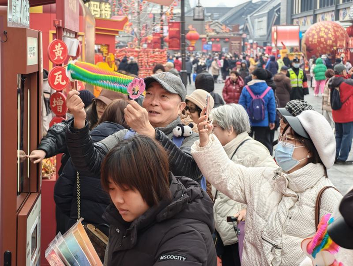 在李梅的摊位前，一位老人在把玩“翻里花”。新京报记者 王巍 摄