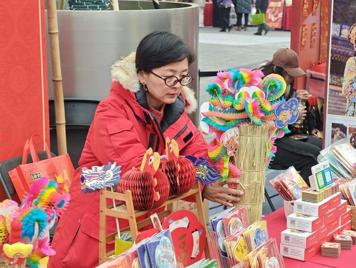 2月25日，北京隆福寺新春市集，“翻里花”非遗技艺传承人李梅正在整理摊位。新京报记者 王巍 摄