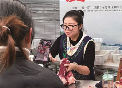杨情正在爱心助农直播间售卖恩施黑猪肉。高舒帆/摄