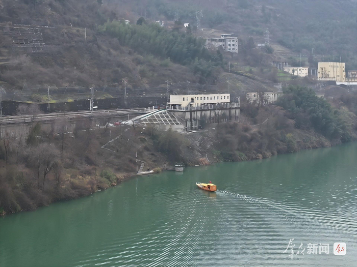 图为彭师傅的渡船正行驶在汉江之上，蜀河车站静静伫立在江岸上。